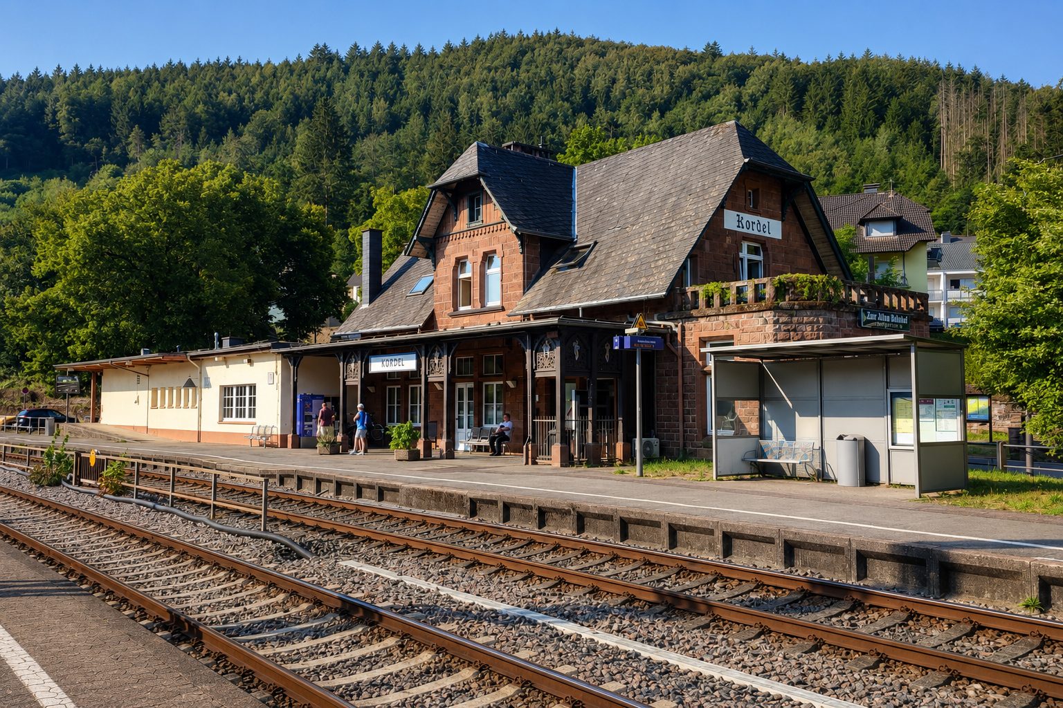 Gordon Schnieder, eine weitere Teilnehmerin und Christoph Biegel sitzen auf einer Bühne und befinden sich im Austausch.