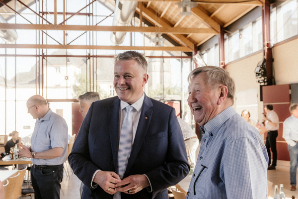 Gordon Schnieder und ein weiterer Teilnehmer stehen im Gespräch und lachen dabei.